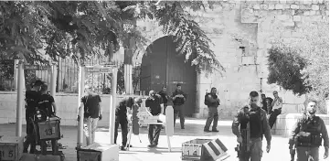  ?? — AFP photo ?? Israeli border policemen install metal detectors outside the Lion’s Gate, a main entrance to Al-Aqsa mosque compound, in Jerusalem’s Old City after security forces reopened the ultra-sensitive site.