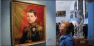  ?? DMITRI LOVETSKY — THE ASSOCIATED PRESS FILE ?? In this Wednesday file photo, a woman watches a portrait of Portugal’s soccer star Cristiano Ronaldo, part of the “Like The Gods” exhibition at the Museum of the Russian Academy of Arts in St. Petersburg, Russia. It’s a collection of digitally made...