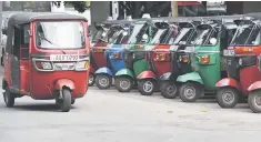  ??  ?? An autoricksh­aw driving past a row of the parked three-wheel taxis on a road in Colombo. The drain of young workers into tuk-tuks compounds a labour crisis for the government, which has overseen robust economic growth since the 37-year civil war ended...