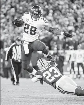  ?? Wesley Hitt Getty Images ?? ADRIAN PETERSON of the Vikings tries to get past Damarious Randall of the Packers in the third quarter while picking up some of his 67 yards rushing.