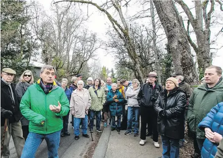  ??  ?? Saanich Mayor Fred Haynes, front left, tours Grange Road with area residents who were concerned that installati­on of a sewage pipe would result in the loss of dozens of trees. But sewage project officials have moved the route to the other side of the road to spare the trees.