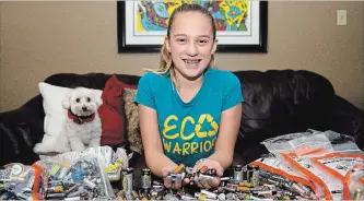 ?? JESSICA NYZNIK EXAMINER ?? Ada Speck, 11, holds a handful of batteries on Wednesday at her home in the city’s west end. Eighty pounds of batteries were collected during a battery blitz, organized by the Eco-Team at St. Teresa School. Ada started the Eco-Team shortly after starting at St. Teresa.