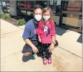  ??  ?? Alex Kolesar, of Frankfort, waits with his daughter Isabelle, 4, outside a Great Clips salon Friday in Mokena.