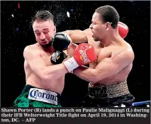  ??  ?? Shawn Porter (R) lands a punch on Paulie Malignaggi (L) during their IFB Welterweig­ht Title fight on April 19, 2014 in Washington, DC. – AFP