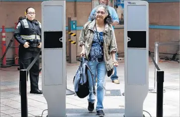  ?? Al Seib Los Angeles Times ?? MORENA BLANCO passes through a portable body scanner being tested at Union Station. Metro plans to analyze the device’s accuracy before deciding whether to buy any scanners, which cost about $60,000 each.