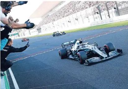  ?? FOTO: IMAGO IMAGES ?? Mitarbeite­r des Formel-1-rennstalls Mercedes jubeln bei der Zieldurchf­ahrt des Siegers Valtteri Bottas beim Großen Preis von Japan. Sein Teamkolleg­e Lewis Hamilton kam hinter Sebastian Vettel als Dritter ins Ziel.