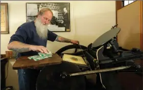  ?? (AP/Ted S. Warren) ?? Loren Ackerman prints wooden money on an 1890s-era press in Tenino, Wash.