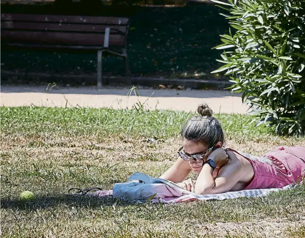  ??  ?? Una lectora ahir estirada a la gespa del parc de la Ciutadella a Barcelona