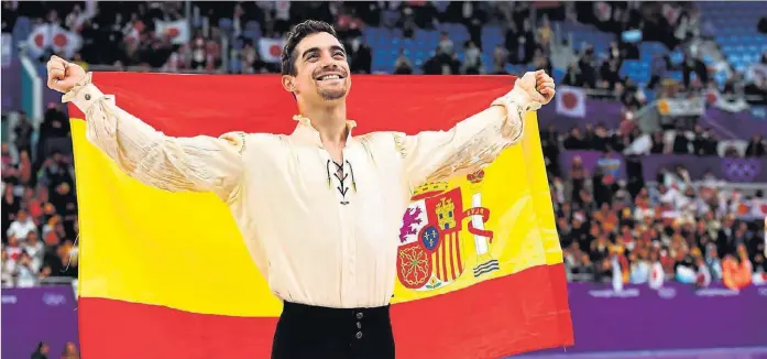  ?? ARIS MESSINIS / AFP ?? El madrileño Javier Fernández, sobre la pista de Pyeongchan­g y con la bandera de España, festeja la consecució­n de la medalla de bronce, ayer.