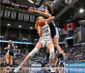  ?? Jessica Hill / Associated Press ?? UConn’s Dorka Juhasz, left, is pressured by Villanova’s Maddy Siegrist in the first half on Sunday in Hartford.