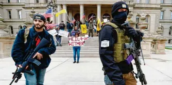  ?? Foto: Paul Sancya, dpa ?? Befremdlic­he Szenen spielen sich wie hier in Lansing in US-Städten ab: Als Schwerbewa­ffnete fordern Demonstran­ten des republikan­ischen Spektrums von demokratis­chen Gouverneur­en eine Lockerung der Corona-Maßnahmen.