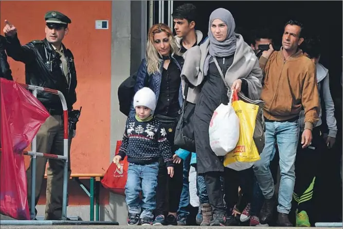  ?? CHRISTOF STACHE / AFP ?? Un grupo de refugiados llegando ayer a la estación ferroviari­a de Munich, después de un fin de semana en que han llegado a Alemania miles de personas