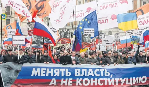  ?? BLOOMBERG ?? Demonstrat­ors march carrying placards of Boris Nemtsov and various national flags including Russian, European Union, and Ukrainian during a rally in Moscow, Russia on Saturday.