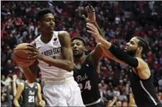  ??  ?? San Diego State forward Malik Pope (left)) looks to pass as Nevada guard Jordan Caroline (center, back) and forward Cody Martin (right) defend during the second half of an NCAA college basketball game Saturday in San Diego. AP PHOTO/GREGORY BULL