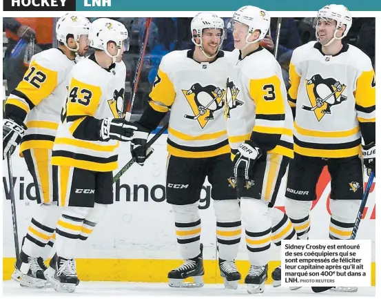  ?? PHOTO REUTERS ?? Sidney Crosby est entouré de ses coéquipier­s qui se sont empressés de féliciter leur capitaine après qu’il ait marqué son 400e but dans a LNH.