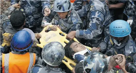  ?? AFP/ Getty Imag es ?? Nepalese police carry earthquake survivor Pemba Tamang on a stretcher after his rescue from a destroyed hotel building in Kathmandu Thursday. The rescue of the 15-year-old was hailed as a miracle and greeted with cheers from onlookers.