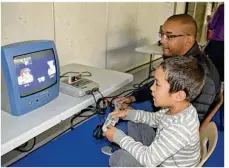  ??  ?? Éric, avec son fils Nathan (7 ans), est venu en famille pour s’amuser sur ces vieilles consoles de jeux de salon.