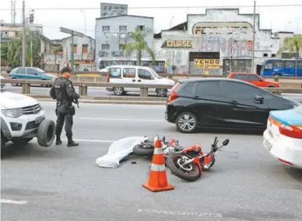  ??  ?? PM vigia local onde o porteiro Eduardo foi assassinad­o: mais uma vítima da violência desenfread­a