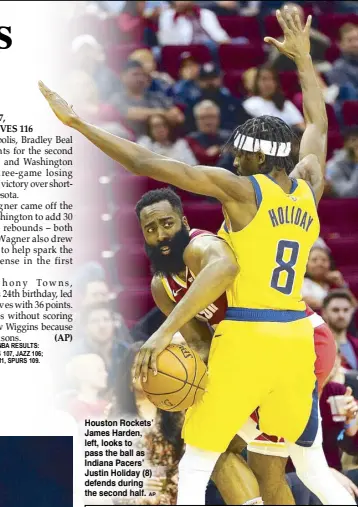  ??  ?? Houston Rockets’ James Harden, left, looks to pass the ball as Indiana Pacers’ Justin Holiday (8) defends during the second half.