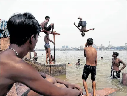 ?? PIYAL ADHIKARY / EFE ?? India. Varios niños indios saltan al río Ganges, mientras se refrescan durante una calurosa tarde en Calcuta.