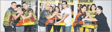  ??  ?? Stephen Kee (fourth left) and Zil (fourth right) and others participat­e in an mock armwrestli­ng contest on the new Mazurenko equipment at Premier 101 Armwrestli­ng Club gym on Friday evening.