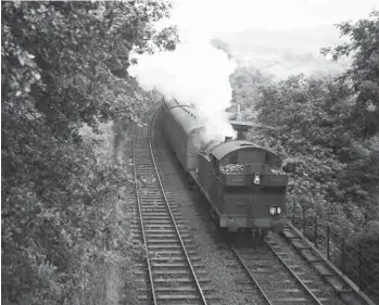  ?? S Rickard/J & J Collection ?? At Treforest Junction the main TVR line continued to Cardiff whilst a line also diverged to Tonteg Junction and then on to ex-Barry Railway metals. Treherbert-allocated Collett 0-6-2T No 5607 is climbing the 1 in 69 bank from Treforest Junction to Tonteg Junction with an excursion from the Rhondda Valleys to Barry Island on 1 August 1960. In the right background the TVR lines to Cardiff can be seen. By this date the diesel-multiple-unit fleet was restrictin­g steam operations to goods work, but an excursion has proved to be another matter.