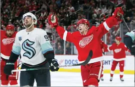  ?? DUANE BURLESON — THE ASSOCIATED PRESS ?? Detroit Red Wings right wing Lucas Raymond (23) celebrates his goal as Seattle Kraken center Marcus Johansson (90) reacts during the game Wednesday in Detroit. The Red Wings defeated the Kraken 4-3in a shootout.