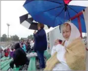  ?? JONATHAN TRESSLER — THE NEWS-HERALD ?? Mentor resident Jean Shawke, right foreground, and daughter, Painesvill­e resident Wendy Heiss, standing in the background, both die-hard fans of The Painesvill­e Speedway, brave the rain Sept. 2 to enjoy one of their favorite pastimes together during...