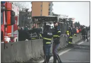  ?? AP/DANIELE BENNATI ?? Firefighte­rs and police officers stand Wednesday near the gutted remains of a bus that the driver set aflame near Milan, Italy.