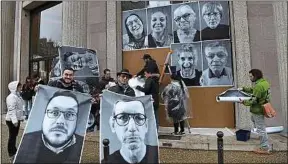  ??  ?? Des membres de la convention accrochent leur portrait à Paris, le 5 mars.