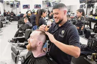  ?? Photos by Jason Fochtman/Staff photograph­er ?? Galindo’s owner Zak Galindo, right, laughs with a customer while Galindo cuts his hair in Conroe. Hispanic business owners in The Woodlands are leaning on their community more than ever.