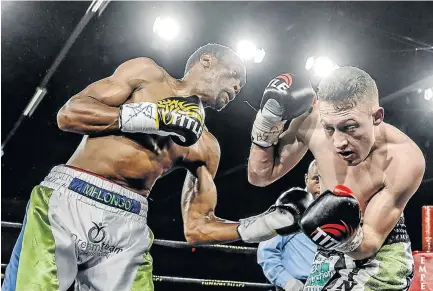  ?? / NICK LOURENS ?? SA junior middleweig­ht champion Nkululeko Mhlongo digs an uppercut to Brandon Thysse's body. Mhlongo stopped Thysse in the 10th round on Saturday night.