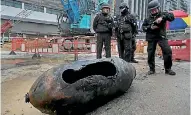  ?? PHOTO: AP ?? Police officers from explosive ordinance disposal next to a deactivate­d bomb in the Wan Chai district of Hong Kong.
