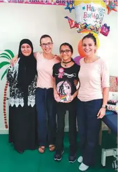  ??  ?? Mai Yezji, with her mother (left) and therapists, celebrates her 13th birthday at the Children’s Medical Centre, Dubai, where she was undergoing an intense physiother­apy programme.