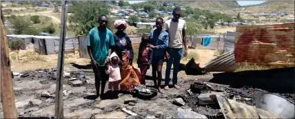  ?? ?? Gutted… The family in front of their shack that burned to ashes.