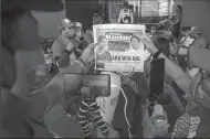  ?? LAUREN DECICCA/GETTY IMAGES ?? Supporters of Ferdinand “Bongbong” Marcos Jr. and Sara Duterte hand out newspapers that read “BBM, Sara Win Big” outside of his headquarte­rs in Manila as partial results showed him in the lead on May 10.