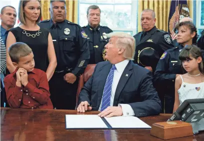  ?? EVAN VUCCI/AP ?? TOP: Kristen Glasser (Ieft), wife of fallen Phoenix police Officer David Glasser, was on hand for a signing ceremony during which the president declared May 15 Peace Officers Memorial Day.