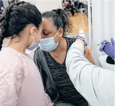  ?? /GETTY IMAGES ?? Mia Rosado, de 8 años, acompaña a su abuela Jacquline Flynn, a recibir la vacuna.