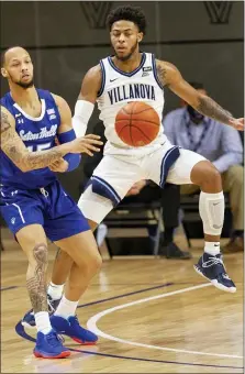  ?? LAURENCE KESTERSON — THE ASSOCIATED PRESS ?? Seton Hall’s Takal Molson (15) passes the ball past Villanova’s Justin Moore (5) late Tuesday night in Radnor. Villanova won, 76-74.