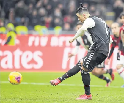  ??  ?? Juventus’ Cristiano Ronaldo scores against AC Milan from the penalty spot in the Italian Cup.