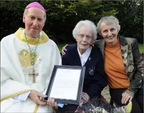  ??  ?? Sr Rita Clare receiving the President’s letter from Bishop Denis Brennan. Also pictured is Sr Miriam Kerrisk.