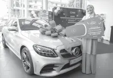  ??  ?? The first prize of winner of Cabutan Wow! SSPN-i Plus 2020, Sonita Sudin, posing with a Mercedes Benz C200 FL AMG Line.