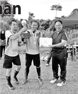  ??  ?? ISA Jasmi (kanan) menyampaik­an hadiah johan bola sepak kepada Ketua Unit Sukan Kudat, Hamdy Sapikit sambil disaksikan oleh Pengurusny­a, Sharulniza­m Abas.