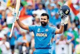  ??  ?? Reprieve: Rohit Sharma raises his bat and helmet to celebrate scoring his century