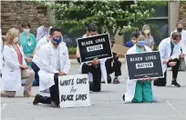  ?? MOUNTAIN AREA HEALTH EDUCATION CENTER VIA AP ?? Physicians, residents and staff from a facility in Asheville, N.C., take a knee June 5 to show support for renewed calls for racial justice after the police killing of George Floyd.