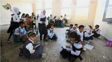  ??  ?? Bleak future: Yemeni students studying at a classroom on the first day of the new academic year on Sept 16 at a school that was damaged last year in an airstrike during fighting between government forces and the Houthi rebels in the country’s third-city of Taez. — AFP