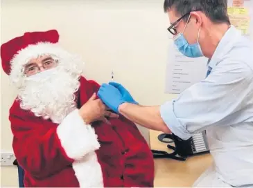  ?? . ?? Santa gets his jab ready for his big night of present delivery