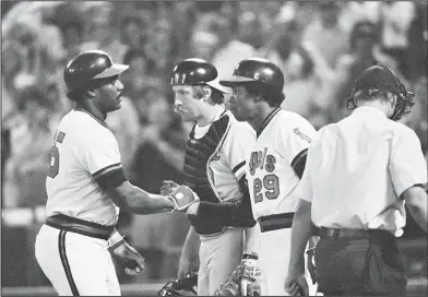  ?? Associated Press ?? Greetings at home plate: In this Oct. 5, 1979, file photo, California Angels' Don Baylor, left, gets a handshake from teammate Rod Carew (29) after hitting a home run in the fourth inning of Game 3 of the American League playoffs against the Baltimore Orioles in Anaheim, Calif. Baltimore catcher Dave Skaggs is at center. Baylor, the 1979 AL MVP with the California Angels who went on to become the Manager of the Year with the Colorado Rockies in 1995, has died. He was 68. Baylor died Monday at a hospital in Austin, Texas, his son, Don Baylor Jr., told the Austin American-Statesman.