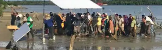  ??  ?? Concern over treatment: The refugee extras stand on a muddy riverbank as they film the hit BBC drama in Malaysia