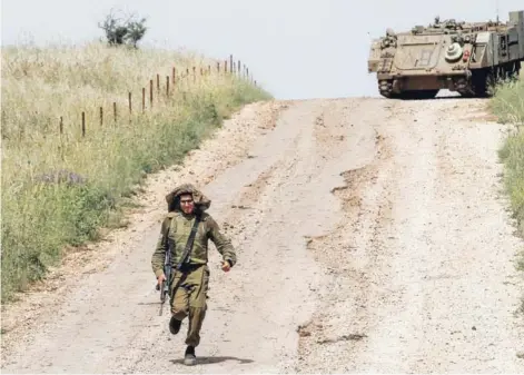  ??  ?? ► Un soldado israelí corre, ayer, en los Altos del Golán, en la frontera con Siria.